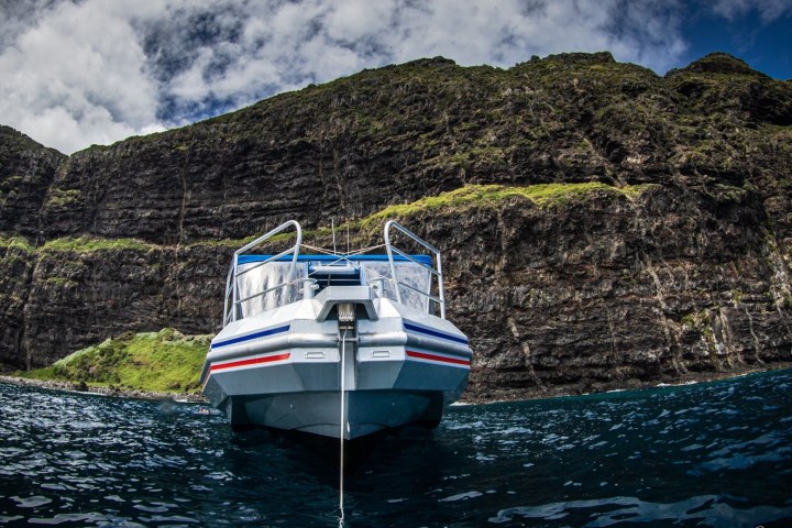 a small boat in a body of water with a mountain in the background