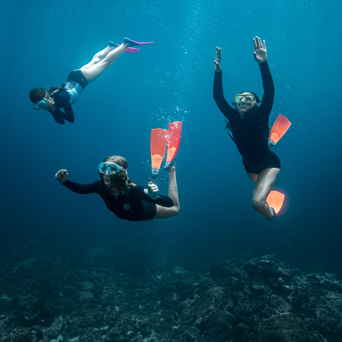 three people swimming in the water