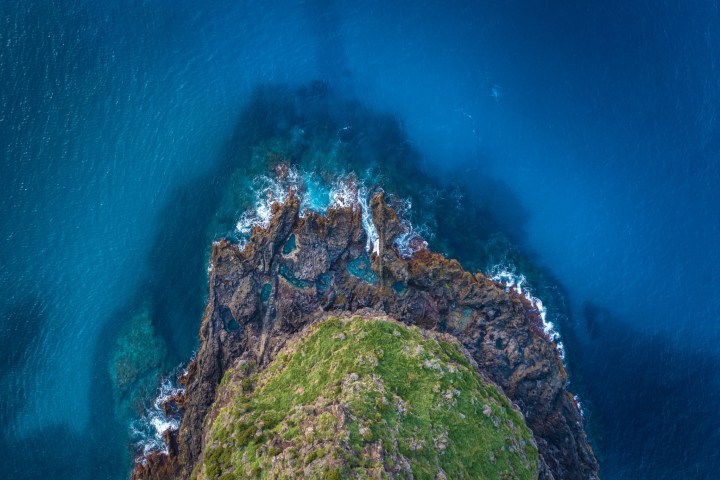 a large waterfall next to a rock wall
