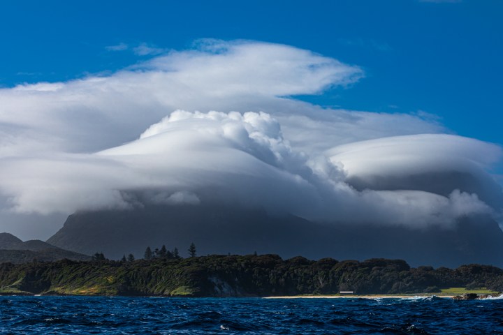a large body of water with a mountain in the background